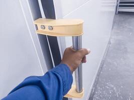 le main tenir le manipuler glissement porte dans couloir pièce pour ouvert ou fermé. le concept pour moderne glissement porte fonction. photo