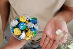 Jeune homme verser eau de Cologne à un aîné homme avec une bol de bonbons ou Chocolat. eid Al fitr dans dinde Contexte . traditionnel eid Al fitr des sucreries. photo