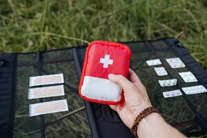 une voyage à nature, prendre une premier aide trousse sur le route, tenir une sac avec médicaments dans votre main, une ensemble de médicaments dans la nature. photo