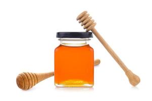 miel avec louche de miel en bois sur pot photo