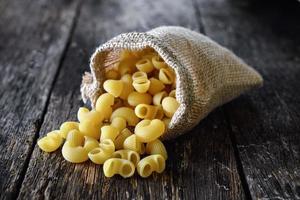 macaroni dans le sac sur table en bois photo