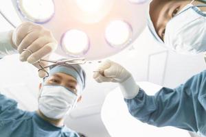 assistant distribue des instruments aux chirurgiens pendant l'opération. concept de chirurgie et d'urgence