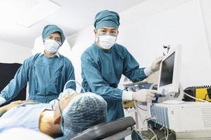 le chirurgien assistant a mis le patient sur un masque de ventilation-oxygène en vue de la chirurgie. photo