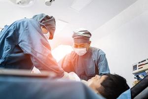 chirurgien opérant un patient avec un assistant dans la salle d'opération. concept de chirurgie et d'urgence photo