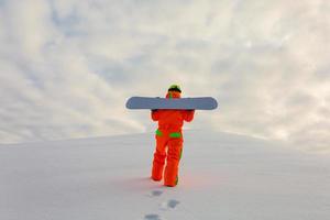 snowboarder grimpant au sommet d'une piste de ski photo