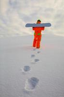 snowboarder grimpant au sommet d'une piste de ski photo