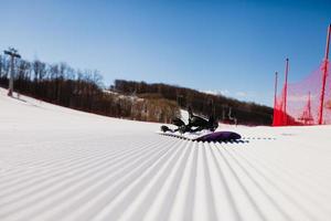 vue de dessous sur une piste de ski vide et équipement pour le snowboard