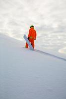 snowboarder grimpant au sommet d'une piste de ski photo