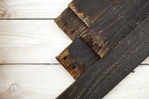 planche de bois noir sur fond de texture en bois blanc.