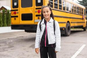 enfant Aller retour à école. début de Nouveau école année après été vacances. peu fille avec sac à dos et livres sur premier école journée. début de classe photo