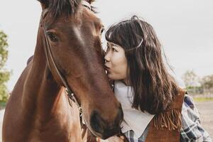 mignonne chinois cow-girl tandis que prise se soucier de sa cheval photo