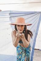 jolie femme avec coloré paille chapeau soufflant confettis photo