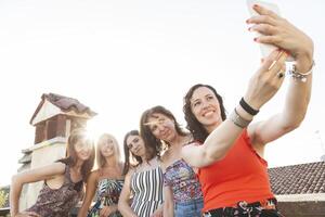 groupe de femelle copains prise une selfie avec téléphone intelligent photo