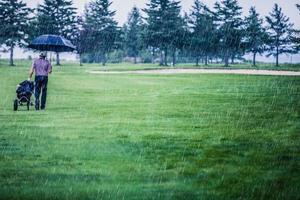 golfeur un jour de pluie quittant le terrain de golf photo