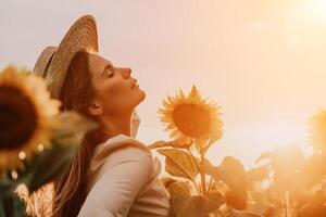 femme dans tournesol champ. content fille dans une paille chapeau posant dans une vaste champ de tournesols à coucher de soleil, prendre plaisir prise image en plein air pour souvenirs. été temps. photo