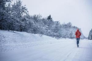 femme qui court seule avec flou de mouvement pendant la froide journée enneigée de l'hiver au canada photo