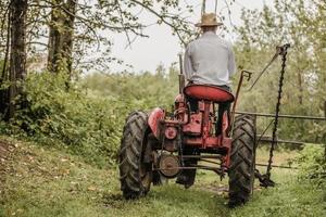 jeune agriculteur sur un tracteur vintage photo