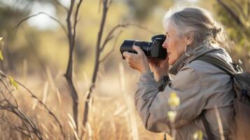 ai généré une âge moyen femme de Océanie, avec une réfléchi expression et une caméra, est photographier faune dans le outback de Australie photo