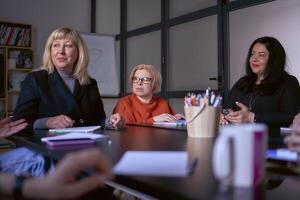 une femme avec invalidité écoute attentivement à une réunion dans le Bureau photo