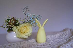 minimaliste Rose sur blanc céramique vase sur table avec Pâques lapin photo