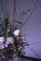 Pâques couronne, nid de saule branches et fleurs décoré avec des œufs et verre tester tubes dans une transparent vase photo