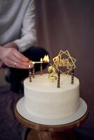 père lumières bougies sur le sien fils seconde anniversaire gâteau photo