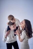 une minimaliste portrait de une mère, père et leur deux ans fils sur une blanc Contexte photo