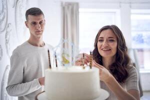 excité maman et fatigué papa décorer leur fils anniversaire gâteau photo