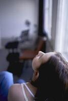 Jeune adolescent fille combat cerveau cancer dans une studio photo tirer séance sur une chaise par le fenêtre