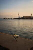 pêche chaise dans le port à le coucher du soleil photo