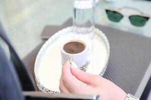 la personne en portant une tasse de café sur plateau photo