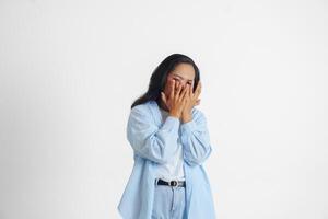 asiatique femme portant décontractée bleu chemise est faire des gestes effrayé geste avec mains et couvrant sa affronter, isolé blanc Contexte photo