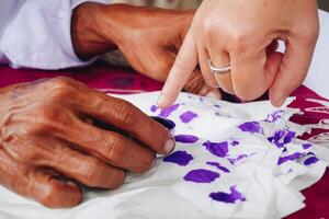 proche en haut portrait de peu doigt plongement dans violet encre après vote pour Indonésie Président et gouvernement élection 2024 photo