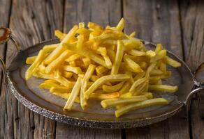 Patate frites servi dans une plat côté vue sur en bois table Contexte photo