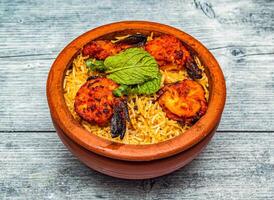 grillé crevette biryani riz servi dans clypot plat isolé sur en bois table Haut vue de Indien épicé nourriture photo