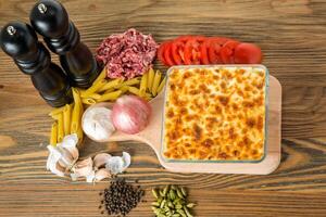 Pâtes béchamel four cuit servi dans plat avec haché Viande, tomate, ail, oignon, noir poivre et cardamome isolé sur table Haut vue de arabe nourriture photo