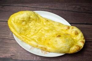 tandoori beurre Nan, Naan, religieuse ou kulcha servi dans plat isolé sur en bois table Haut vue Indien épices nourriture photo