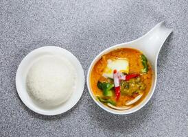 cuit du boeuf flanc Jaune curry dans thaïlandais style avec riz servi dans plat isolé sur gris Contexte Haut vue de Hong kong nourriture photo