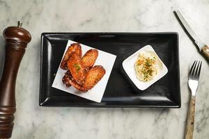 épicé poulet ailes avec tremper servi dans plat isolé sur marbre Contexte Haut vue sur Hong kong nourriture photo