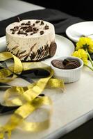 oreo cheesecake comprendre chocolat, crème, sucre avec fourchette et fleurs servi dans assiette isolé sur serviette de table côté vue de café nourriture photo