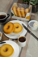 plaine beignets avec tremper et tasse de café isolé sur serviette de table côté vue de cuit nourriture petit déjeuner sur table photo
