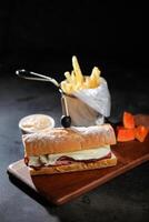 rôti du boeuf sous sandwich avec français frites seau servi sur en bois planche isolé sur foncé Contexte côté vue de petit déjeuner nourriture photo