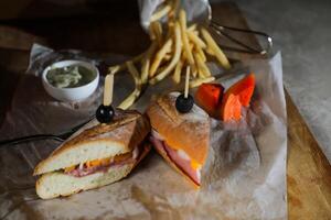 robuste rôti du boeuf Cheddar sandwich avec Mayonnaise tremper avec frites servi dans en bois planche isolé sur serviette de table côté vue de petit déjeuner nourriture photo