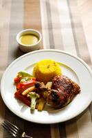 rôti poulet avec herbe riz avec salade, plonger, cuillère et fourchette servi sur assiette isolé sur serviette de table côté vue de vite nourriture sur table photo