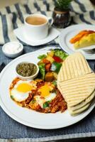 shakshouka avec légume salade comprendre tomate, pomme de terre, salade feuille et carotte avec thé, café, et sucré melon servi sur nourriture table Haut vue en bonne santé petit déjeuner photo