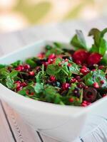 rocca salade acide avec Grenade graines, Olives et herbes feuilles servi dans plat isolé sur table fermer Haut vue de en bonne santé biologique nourriture photo