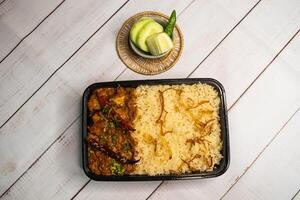 achari poulet Pulao biryani riz avec concombre et citron tranche servi dans plat isolé sur en bois table Haut vue de bangladeshi et Indien épices nourriture photo