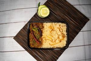 achari du boeuf Pulao biryani riz avec concombre et citron tranche servi dans plat isolé sur en bois table Haut vue fermer de bangladeshi et Indien épicé le déjeuner nourriture photo