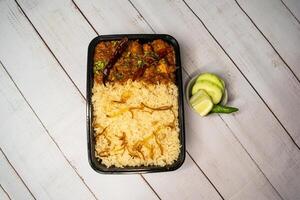 achari poulet Pulao biryani riz avec concombre et citron tranche servi dans plat isolé sur en bois table Haut vue de bangladeshi et Indien épices le déjeuner nourriture photo