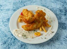 battu poisson avec français frites, citron et tremper servi dans assiette isolé sur Contexte Haut vue de italien nourriture photo